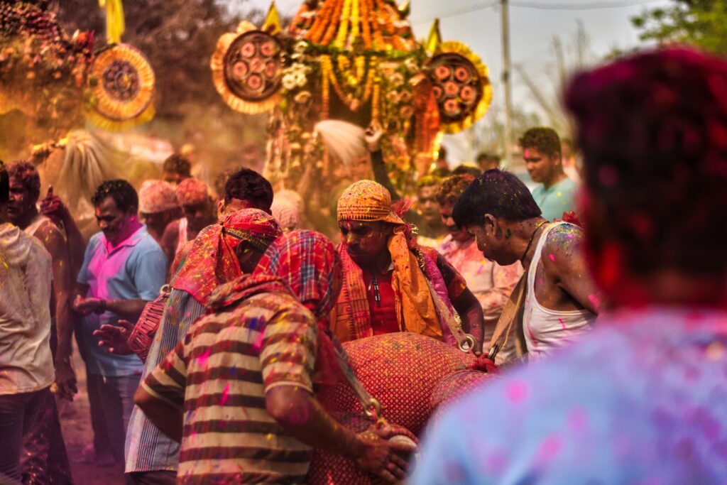 Colorful celebration of an Indian festival in Odisha with people covered in powder.