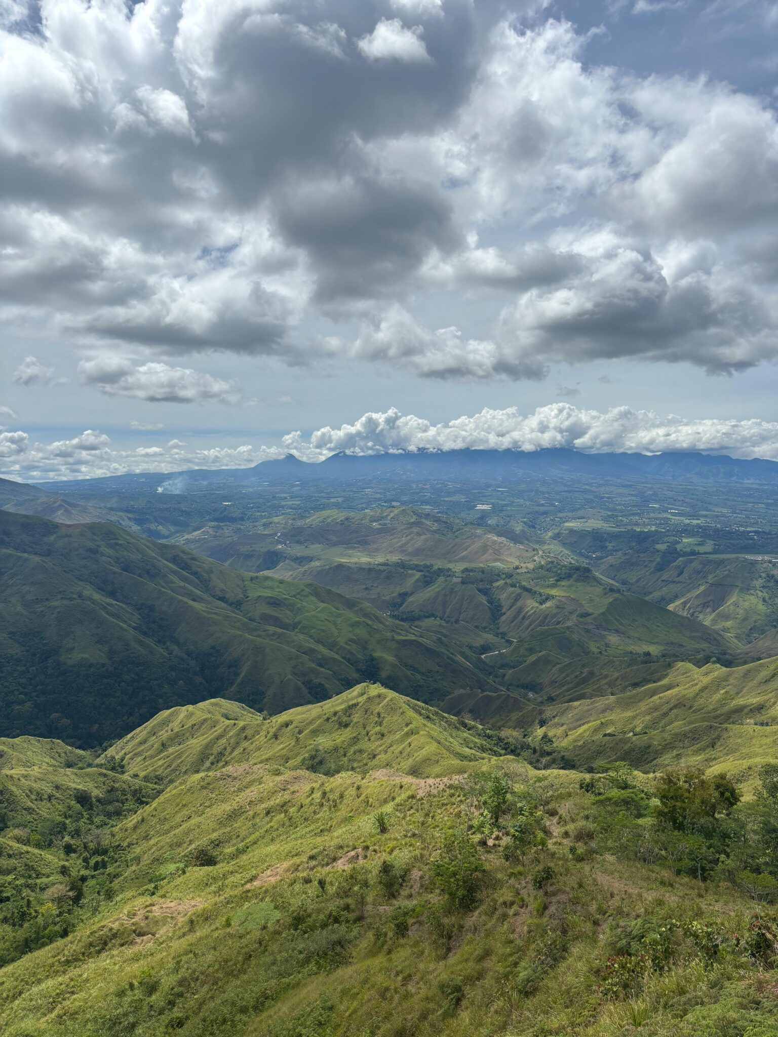 Breathtaking view of lush green mountains and cloudy skies in Northern Mindanao, Philippines.
