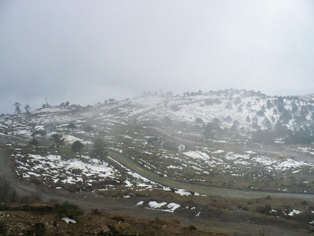 A serene snowy landscape in Tawang captured on a misty winter day.